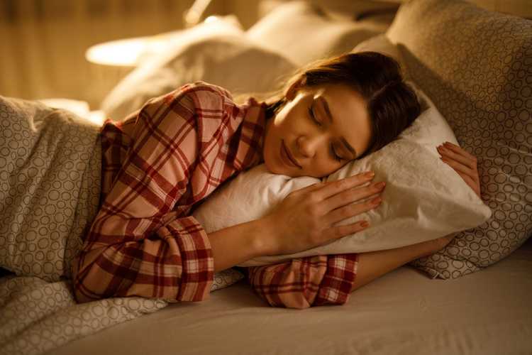 Woman sleeping in bed hugging soft white pillow